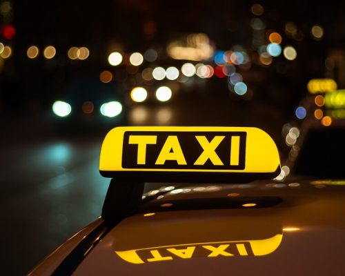 yellow-black-sign-taxi-placed-top-car-night_181624-10624